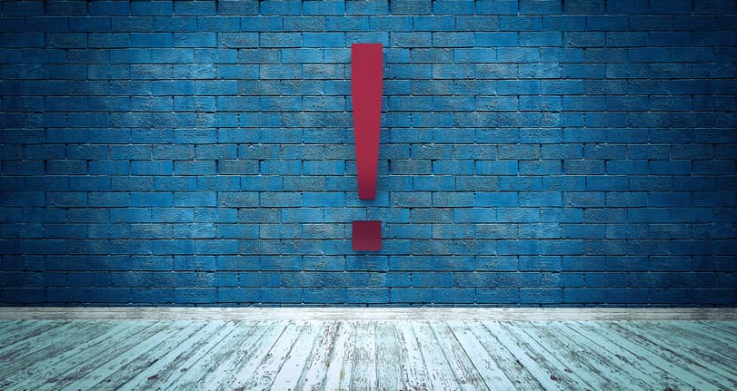Exclamation mark symbol on blue brick wall, warning, caution