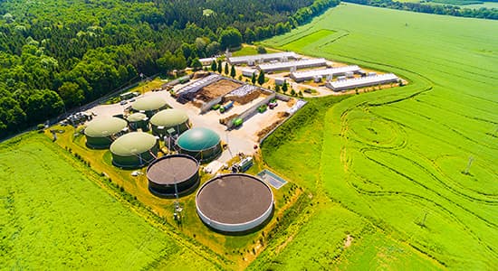 Biogas plant and farm in green fields.