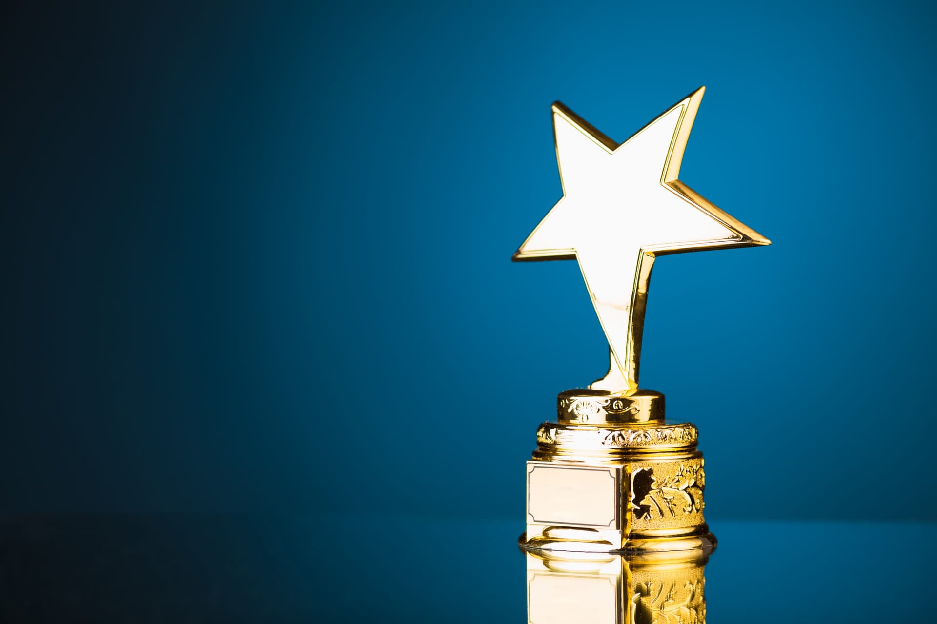 Gold star trophy against blue background