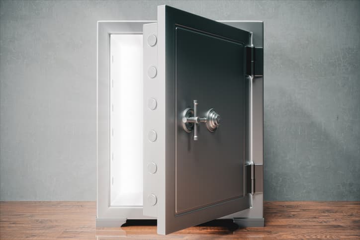 A large metal safe with its door open and light shining through
