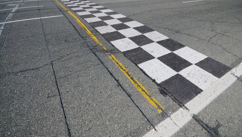 A racecar finish line spanning the pavement.
