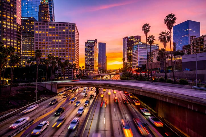 Cars in traffic in Downtown Los Angeles at sunset.