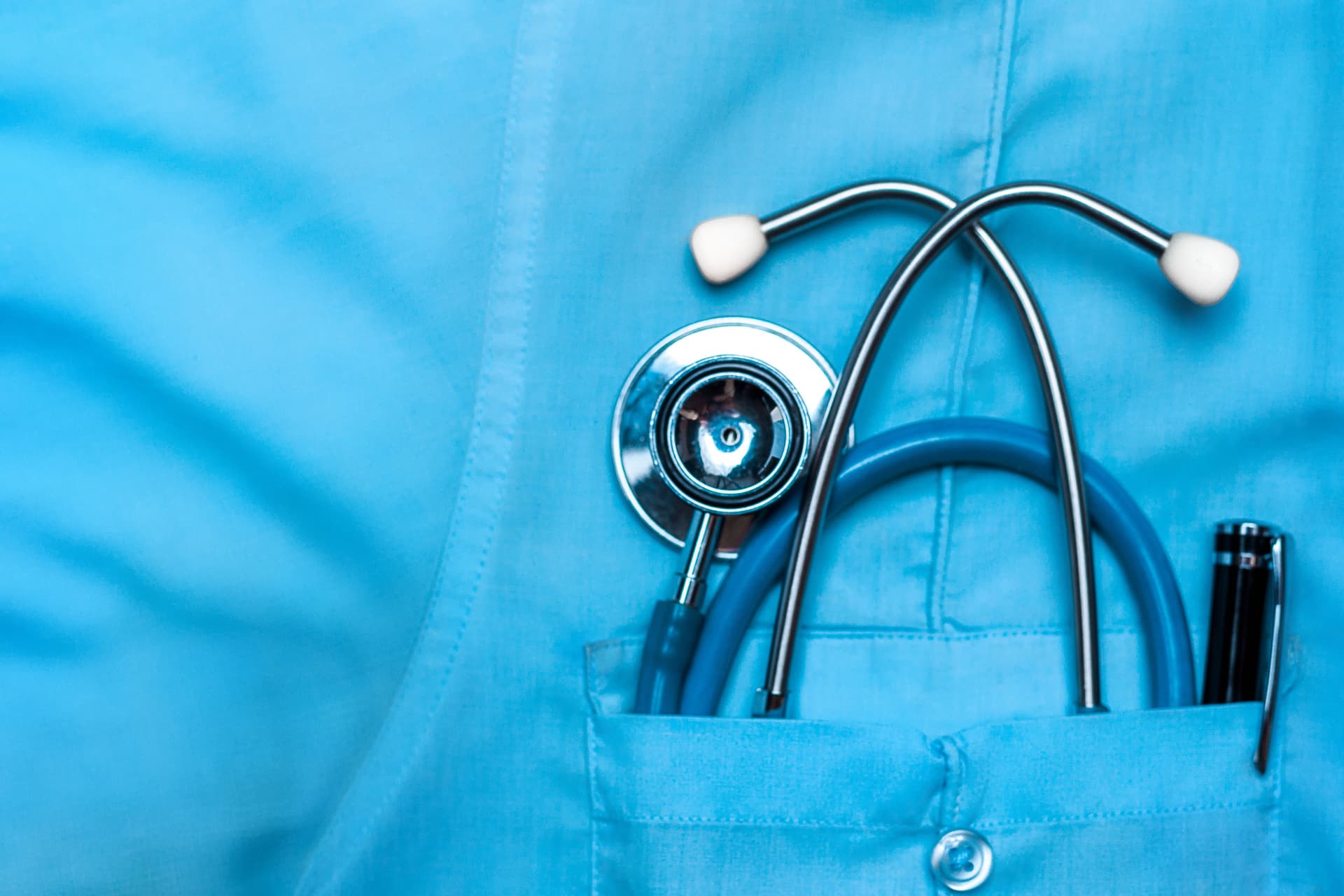 Image of a stethoscope in the pocket of a scrub top.