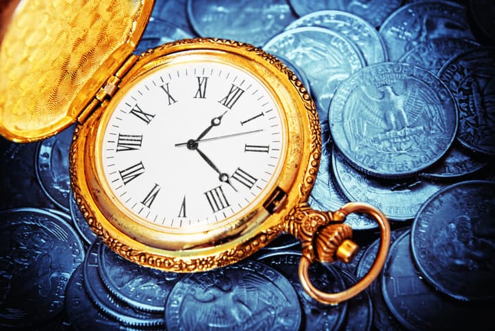 gold watch against US currency