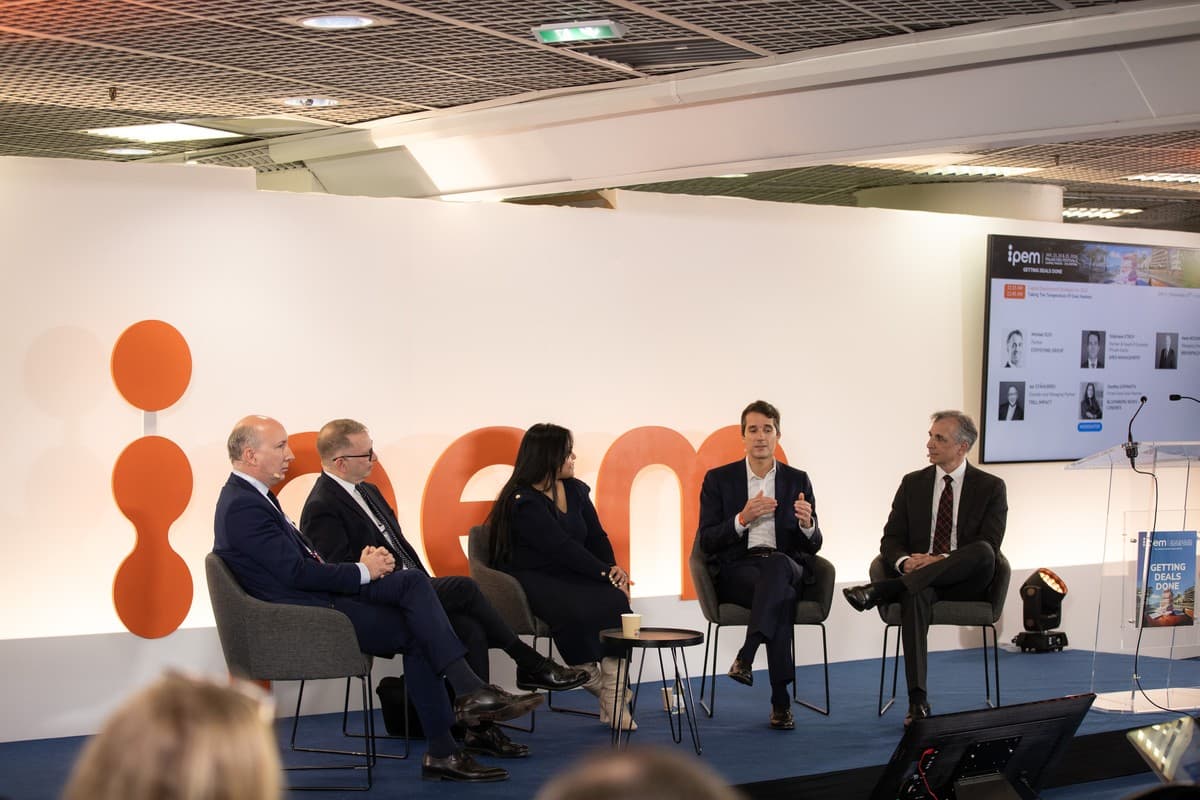 Panellists at IPEM Cannes speaking from a stage