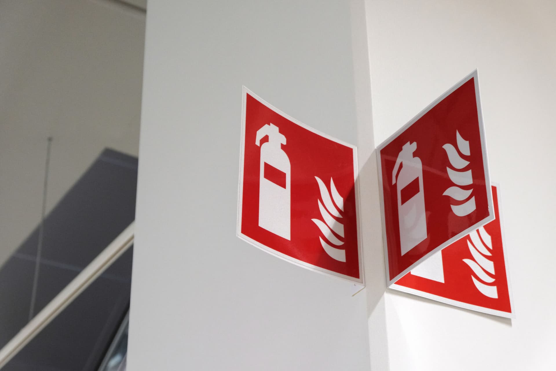A fire extinguisher sign on a white wall
