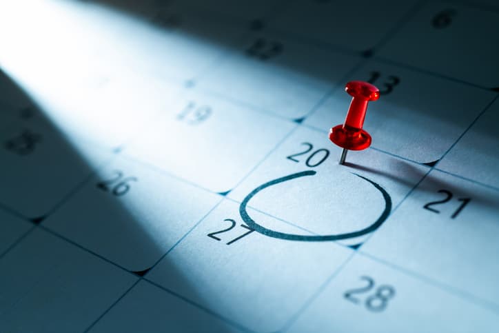 Red push pin on calendar with circle mark on 20