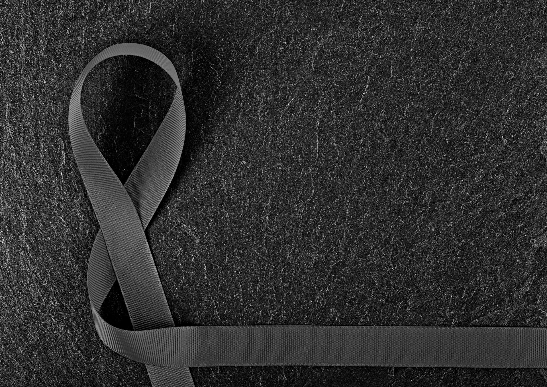 Photograph of a black ribbon against a black marble background